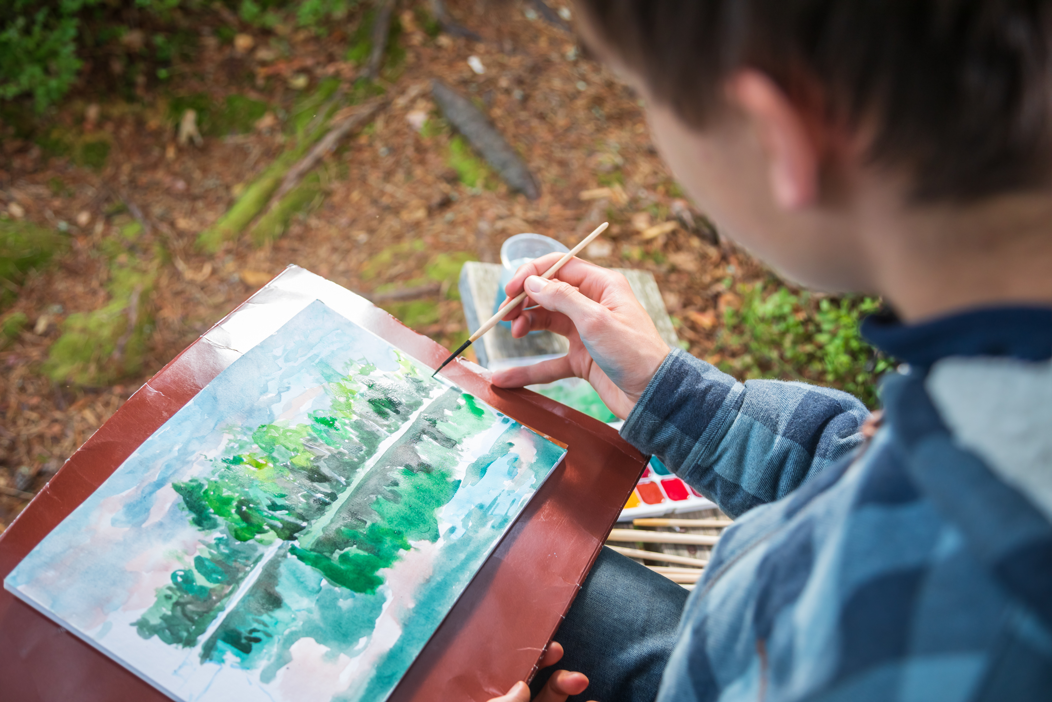 Teen Boy Painting Summer Landscape with Watercolor